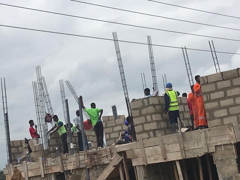 Students working on the upper floor of a building under construction