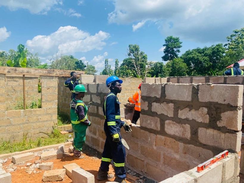 Students plastering a block wall