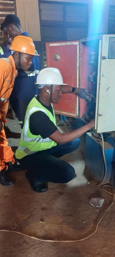 A student working inside an electrical control panel