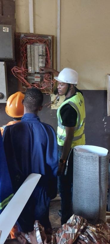 Students inspecting a distribution board with an instructor