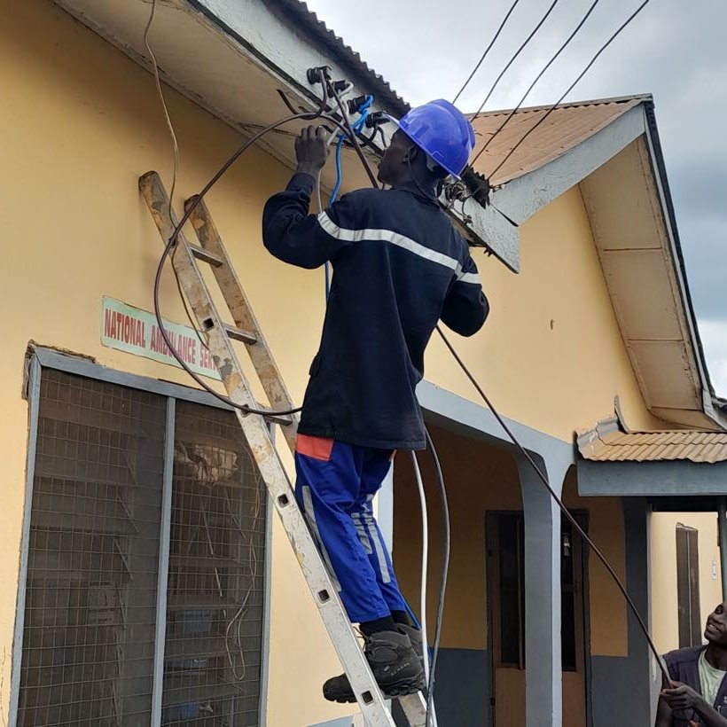 A student on a ladder terminating a service cable
