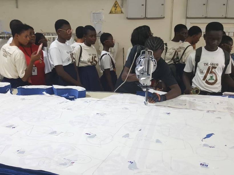 Students watching a cutting demonstration at a factory
