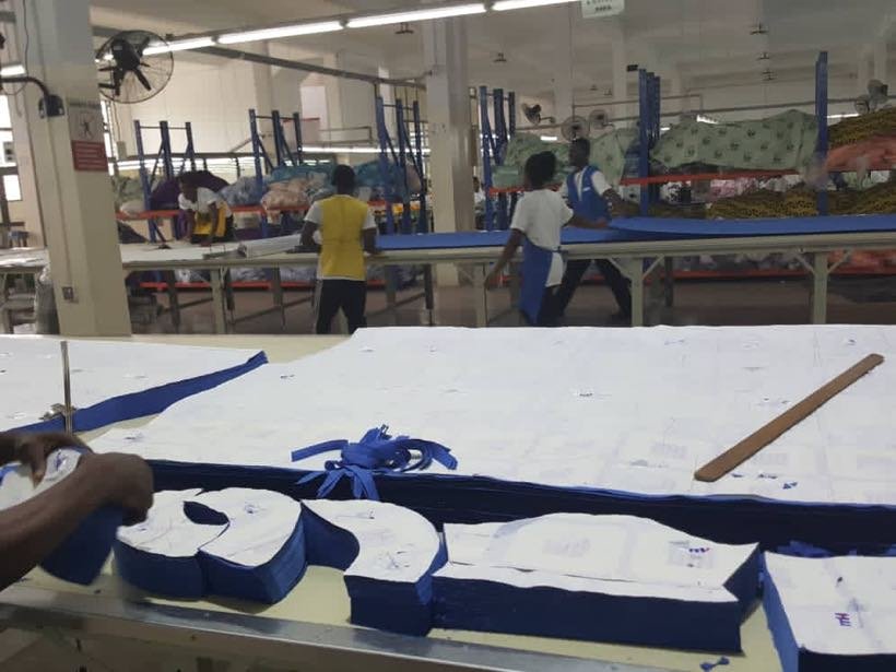 A garment factory floor with fabric laid out for cutting
