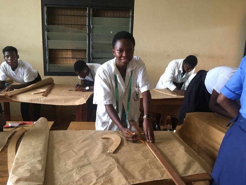 A student drafting a pattern on brown paper