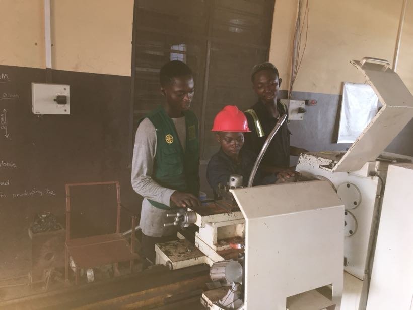 Two students working at a machine in the workshop