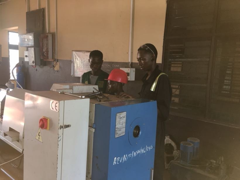 Students operating a bandsaw in the workshop