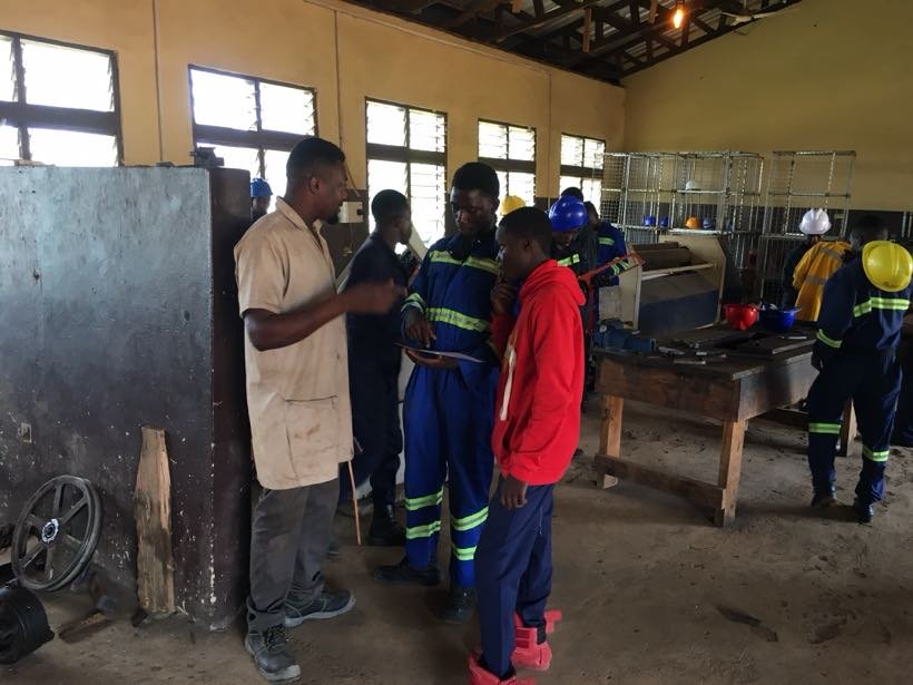 An instructor speaking to students in the workshop