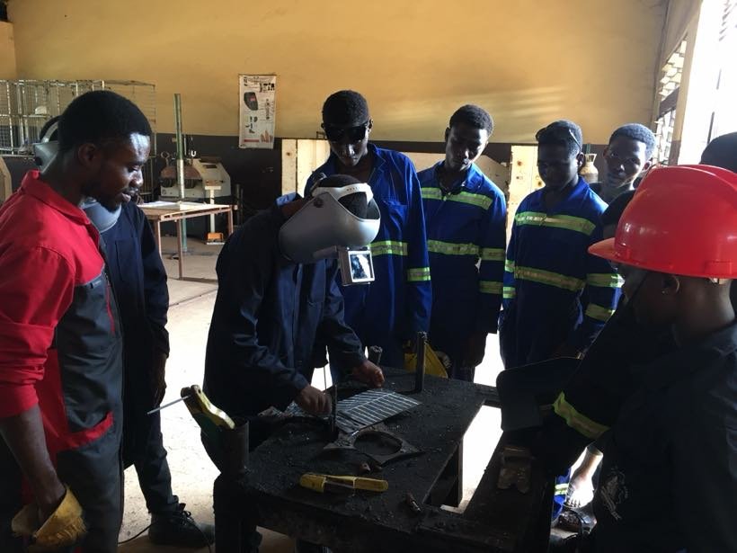 An instructor demonstrating on the workbench to a group of students